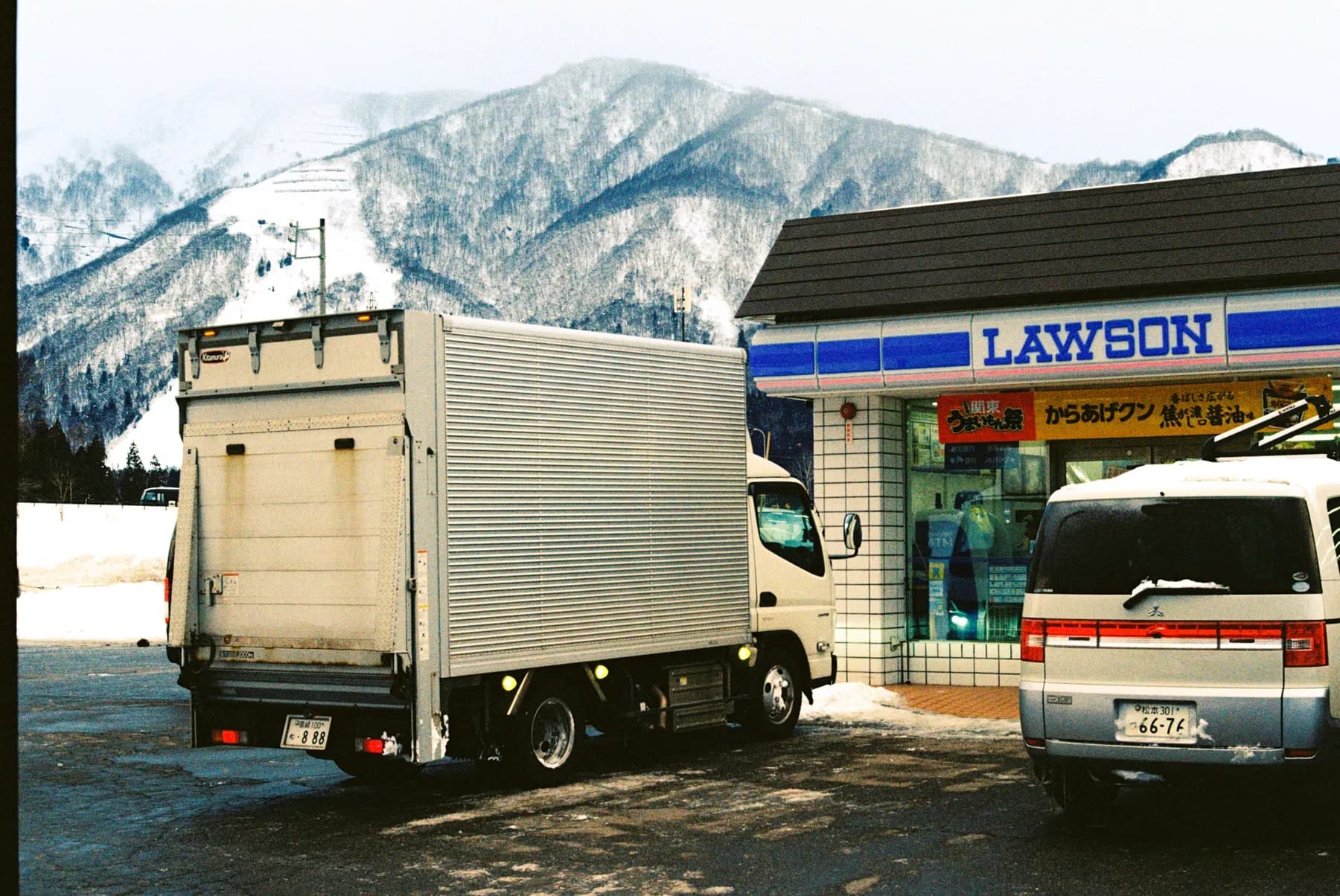 Delivery worker pulling a cart outside a convenience store in the mountains