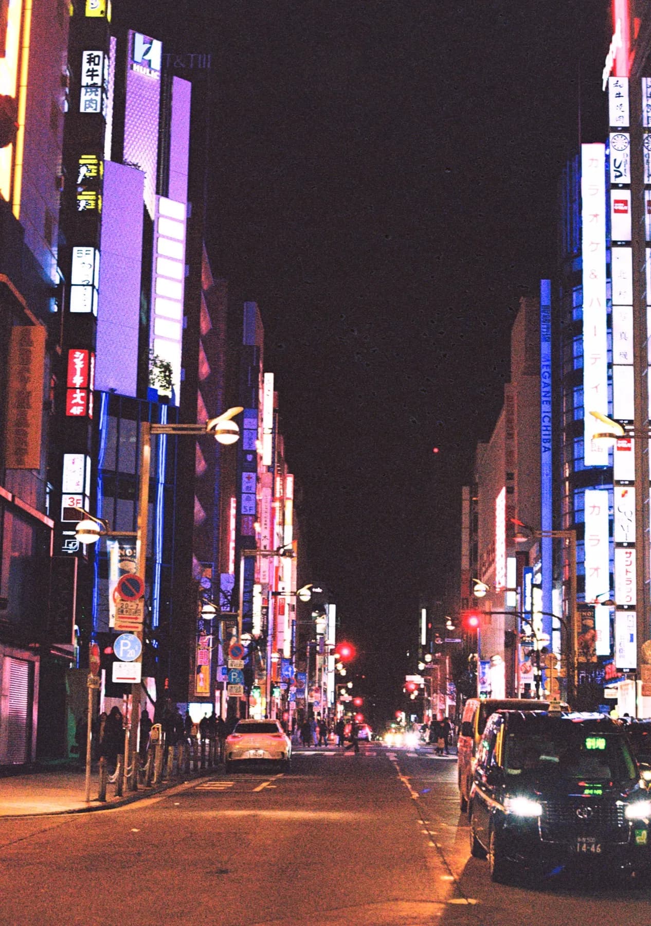 Neon-lit street canyon in Tokyo at night