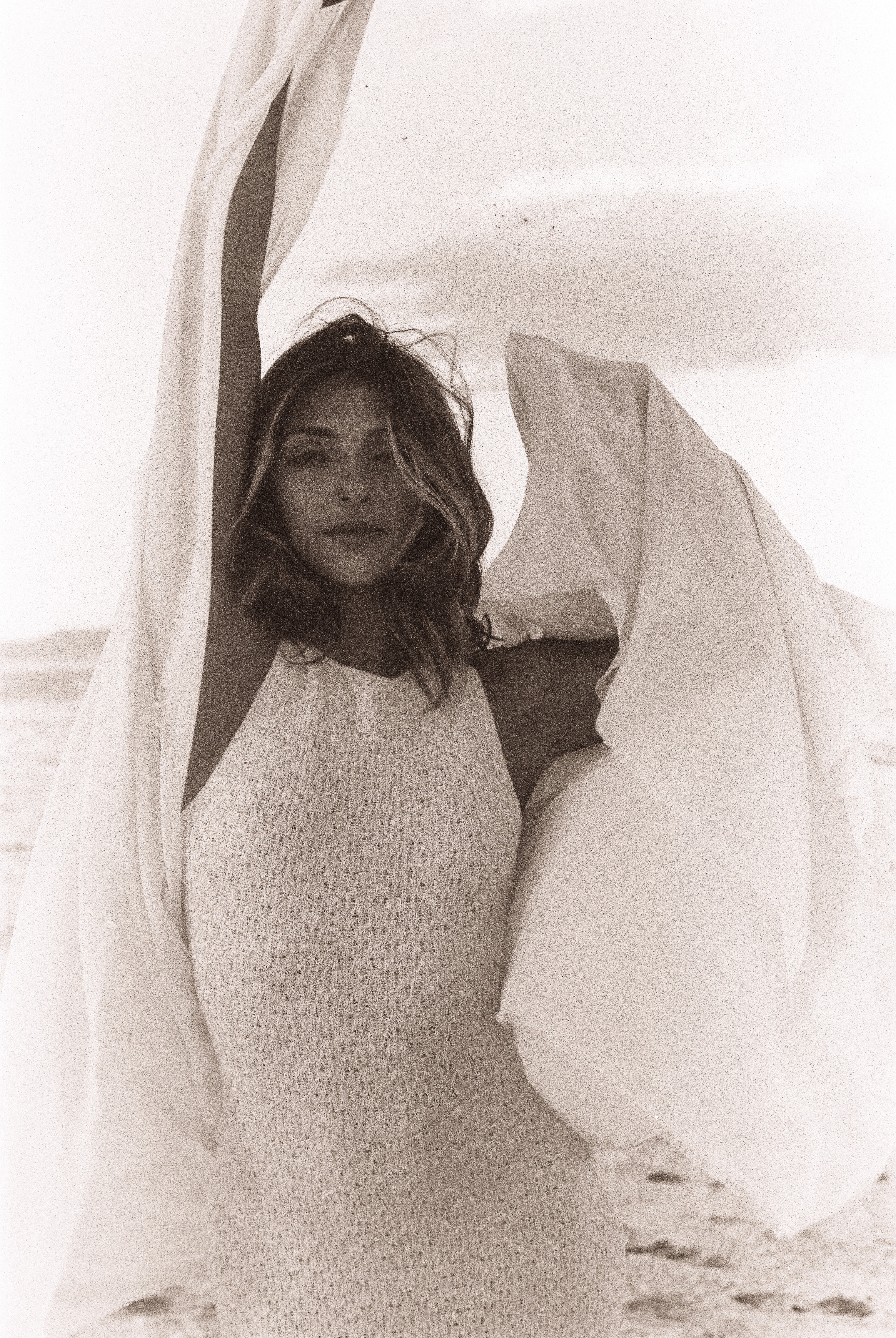 Black-and-white desert portrait by Salt Lake City photographer Grant Parkhurst, featuring a woman framed by billowing fabric with one arm raised.