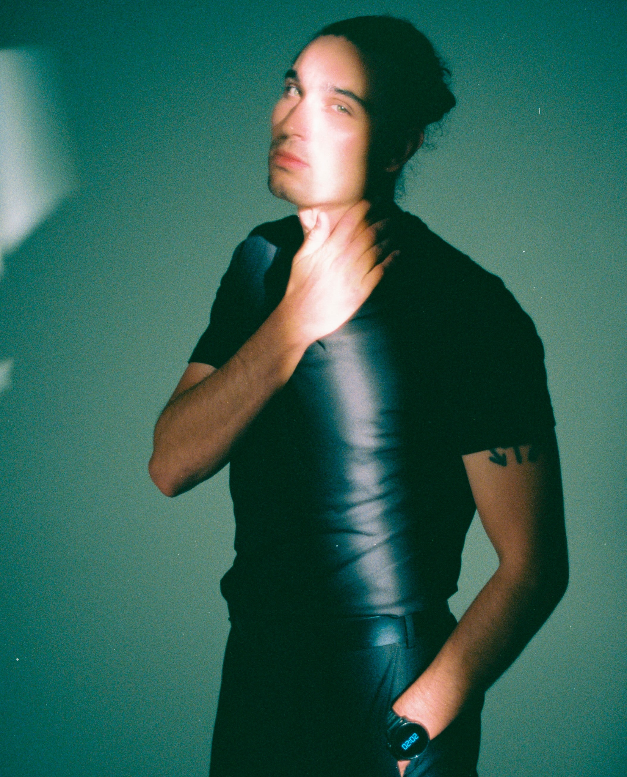 Film studio portrait by Salt Lake City photographer Grant Parkhurst, with a narrow beam of light across a model in a black T-shirt. cine8 cinestill film