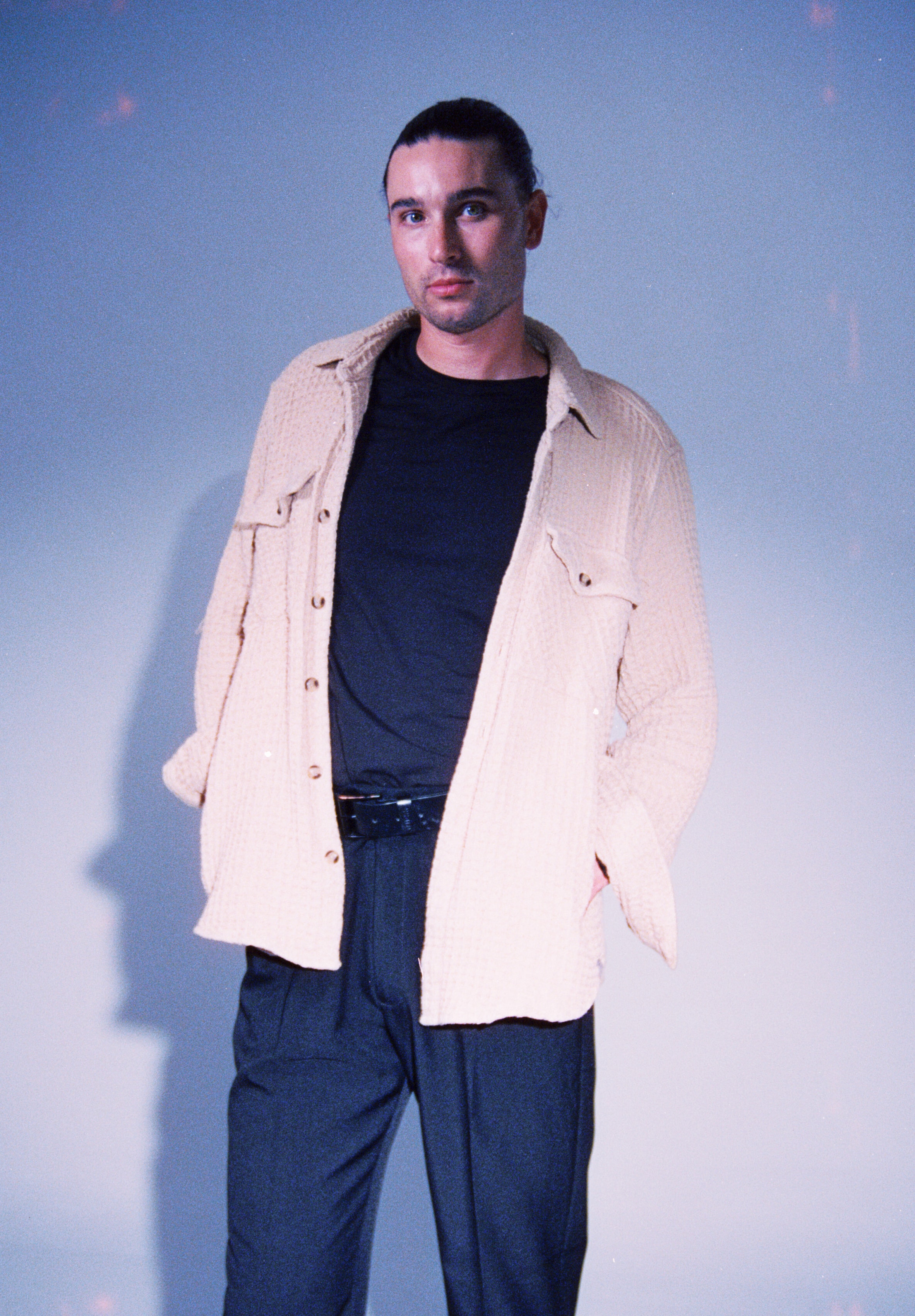 Editorial portrait by Salt Lake City photographer Grant Parkhurst, with a model standing in a cream overshirt under cool studio lighting.